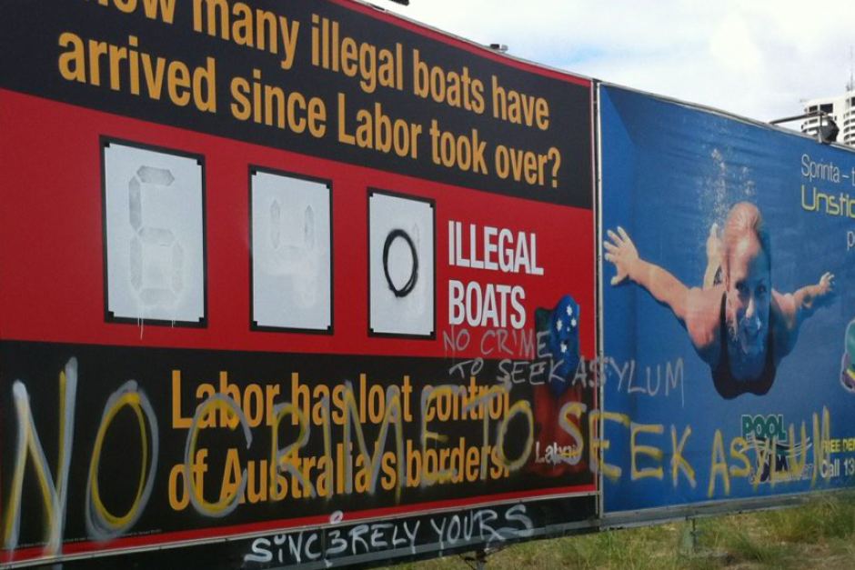 The figures were whited out and turned to zero with 'no crime to seek asylum' written on the Liberal Party billboard. ABC: Barry Duxton
