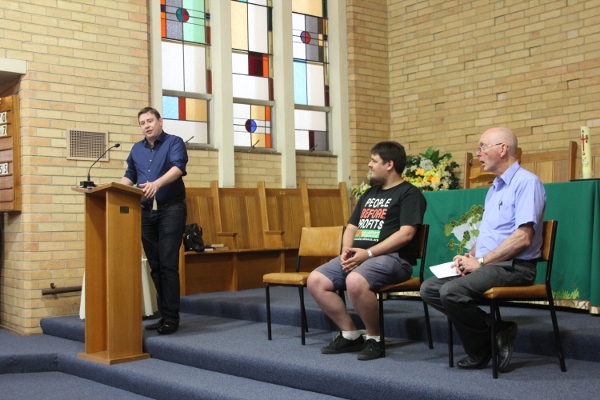 Pascoe Vale candidates Forum: Liam Farrelly (Greens) sopeaking with Sean Brocklehurst (Socialist Alliance) and empty chair for the absent Labor and Liberal candidates. Forum organiser Robert Humphreys on right.